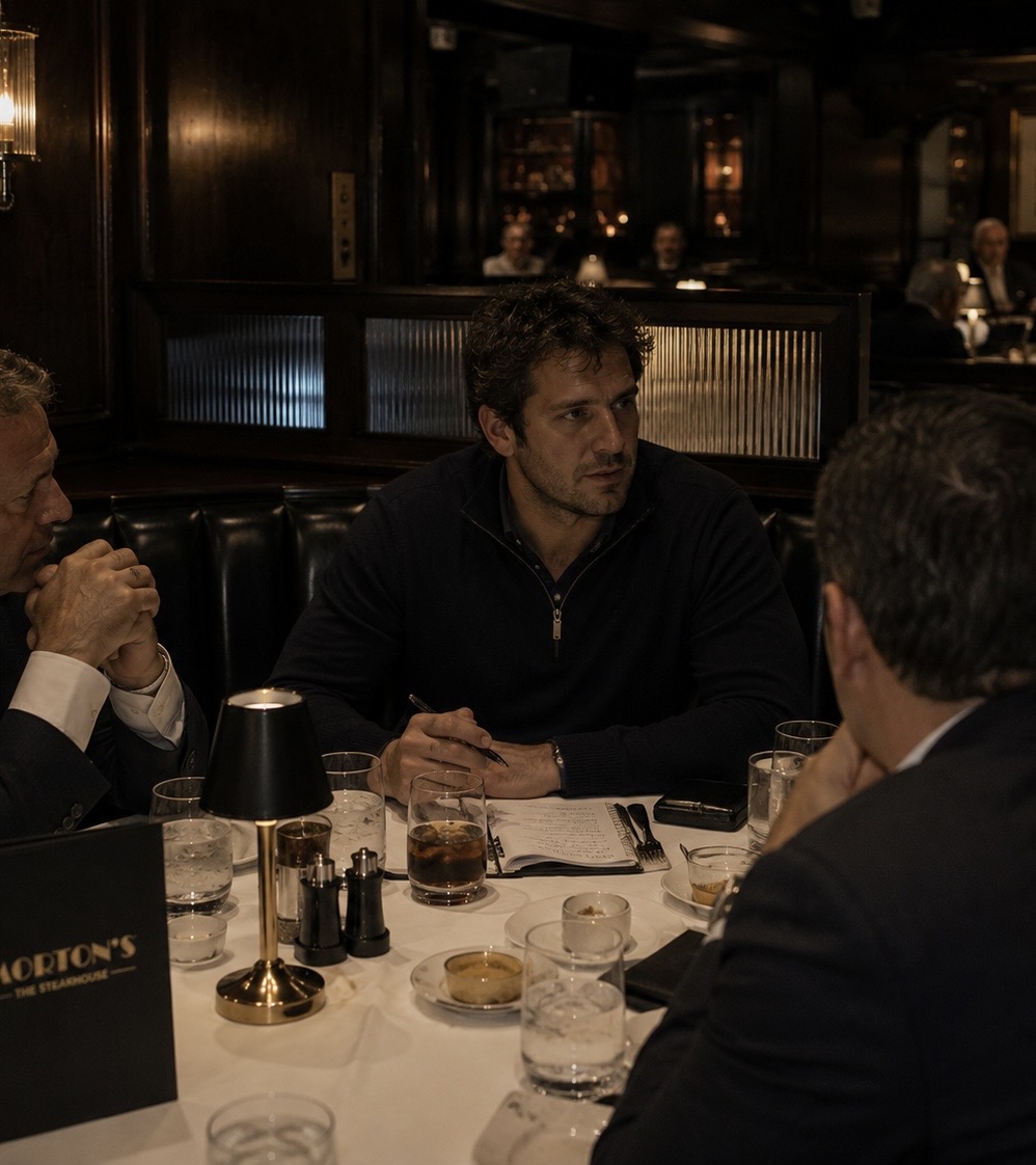 Friends dressed in dark restaurant-ready layers at a steakhouse table.